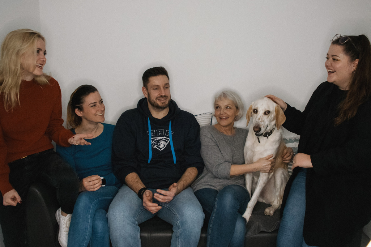 5 Mitarbeiter und ein Office Hund auf einer Couch