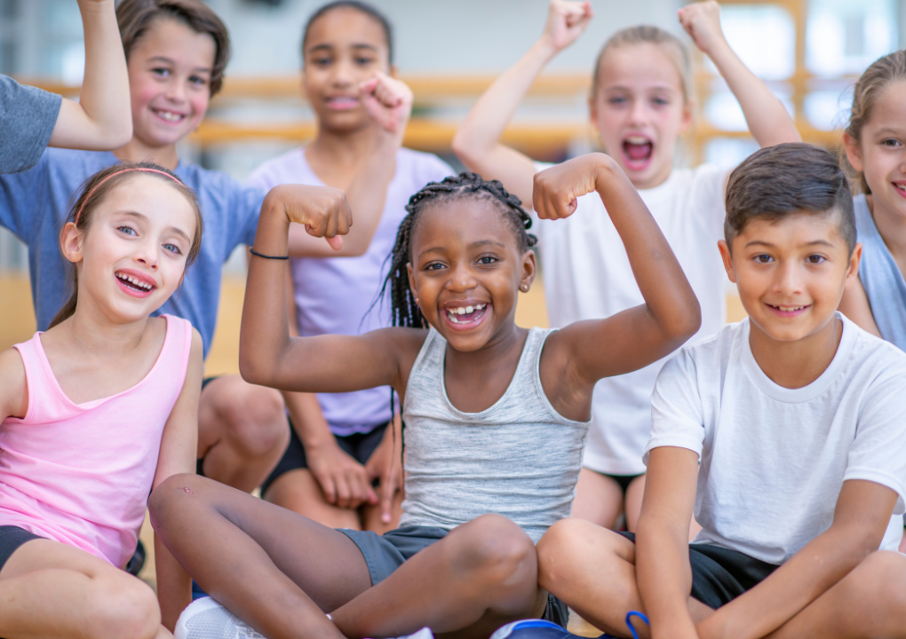 Starke Kinder sitzen auf dem Boden und lächeln