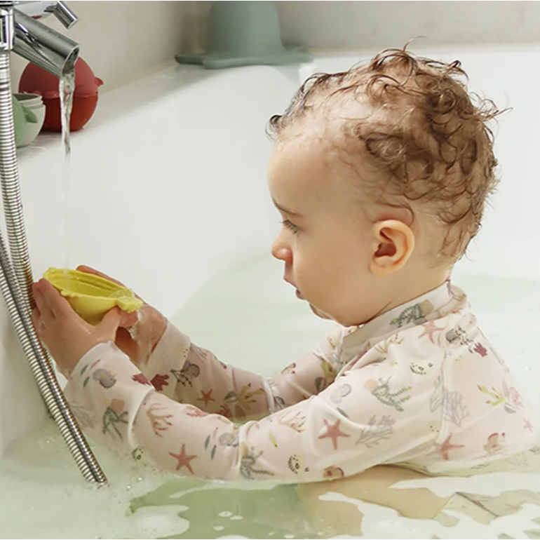 Kind mit Wasserspielzeug in der Badewanne