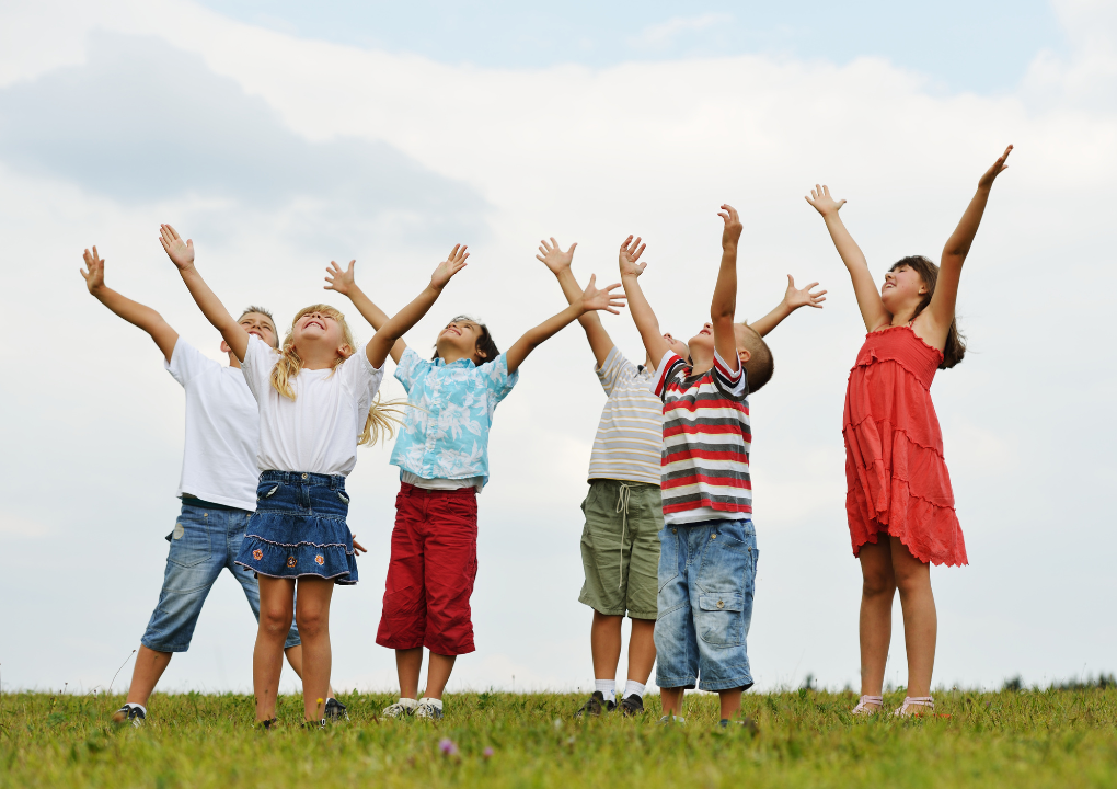 Optimismus und Selbstwirksamkeit bei Kindern Kinder lächeln und schauen zum Himmel