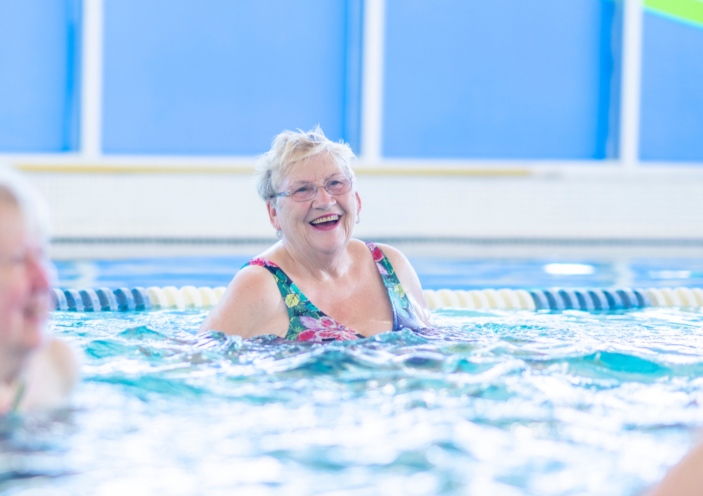 Frau hat Spaß beim Aquafitness im Wasser