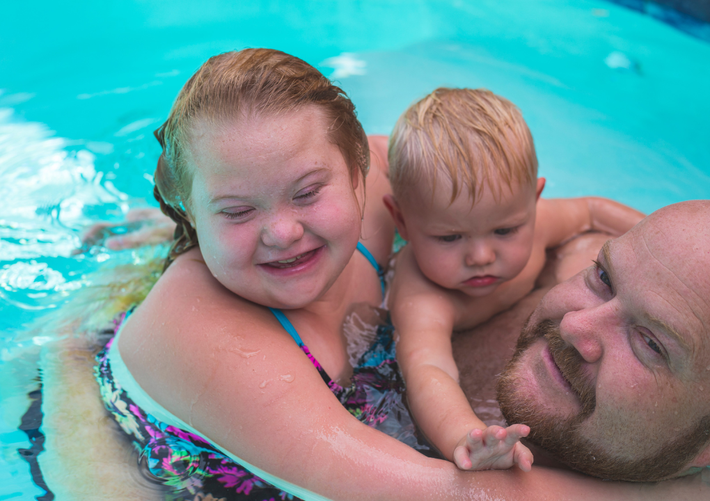 ein Mädchen und ein Junge mit Papa im Wasser