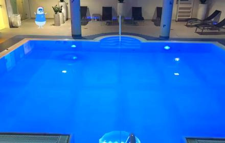 Blick von oben auf das tiefblaue Schwimmbecken im Dorinth Hotel, im Hintergrund eine runde Ausbuchtung mit einem Springbrunnen