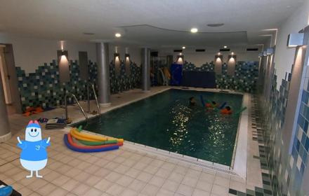 In der Mitte das Schwimmbecken, am Rand fertig für den Unterricht aufgebaut, bunte Nudeln und Schwimmbretter