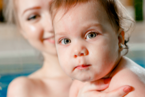 Auch für Schwangere und frisch gebackene Mamas haben wir passende Aquakurse im Angebot ein Kleinkind ist im Haltegriff der Mama beim Babyschwimmen